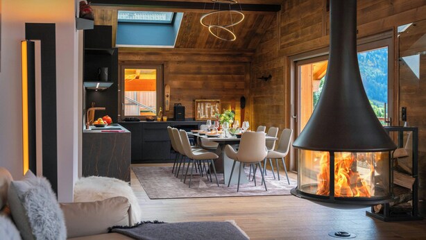 A modern interior with a dining area, kitchen, and a fireplace.