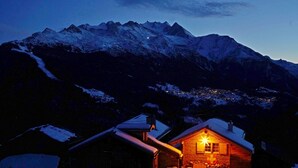 A wooden cabin with a snow-covered roof, surrounded by mountains and a snow-covered landscape. - Authentic, beautiful chalet, from 1679. Refurbished. At an altitude of 1,800 m. (Törbel)