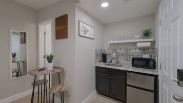 Microondas, cafetera y tetera, utensilios de cocina y comedor