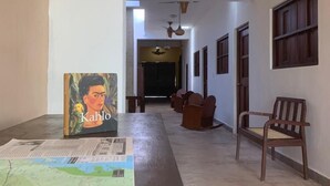 A hallway with a long table, chairs, and a map.