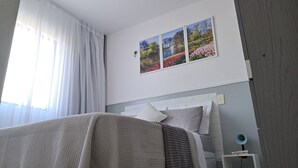 Un dormitorio con cama, una mesita de noche y un cuadro en la pared.