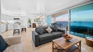 A modern living space with a kitchen, dining area, and a large balcony with a view of the sea. - Luxury Ocean Front Modern Condo in Rosarito BC (Rosarito)
