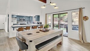 Une cuisine spacieuse, dotée d’appareils électroménagers modernes, et un coin repas avec une table et des bancs en bois.