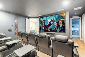 Un cine con asientos de cuero, una pantalla grande y un cartel que dice 'WELCOME'.