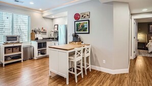 Una cocina compacta con una isla central, microondas, tostadora y un lavabo.