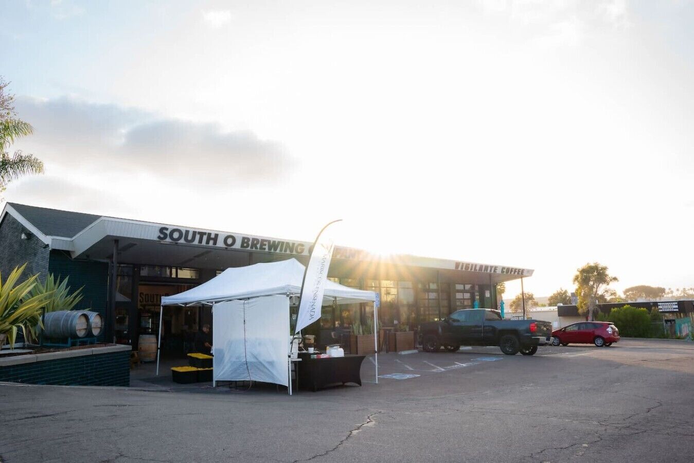 A commercial building with a sign reading 'SOUTH O BREWING' and a white tent in front.