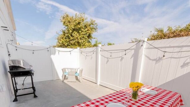 Un patio con una mesa a cuadros, una mesa pequeña y una silla.