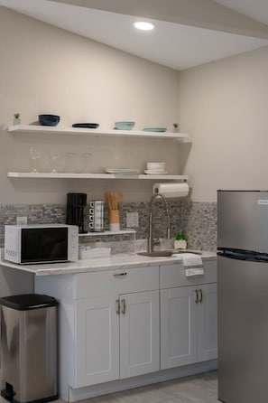 Fridge, microwave, coffee/tea maker, cookware/dishes/utensils