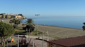 A beach view with a playground, palm trees, and a clear sky. - Beachfront apartment (La Cala del Moral)