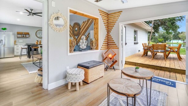 Ein modernes Interieur mit Essbereich, Deckenventilator und Blick ins Freie.