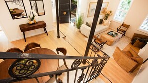 A spacious living area with a wooden staircase, a dining table, and a sofa. - Sweet Juliet, Double Bay (Double Bay)