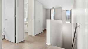 Et moderne hotelværelse med et stort vindue, en brusekabine og udsigt over byen.