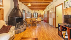 Una sala de estar acogedora con chimenea, muebles de madera y televisor.