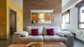Ein modernes Wohnzimmer mit einer Couch, einem Couchtisch und einer Küche im Hintergrund.