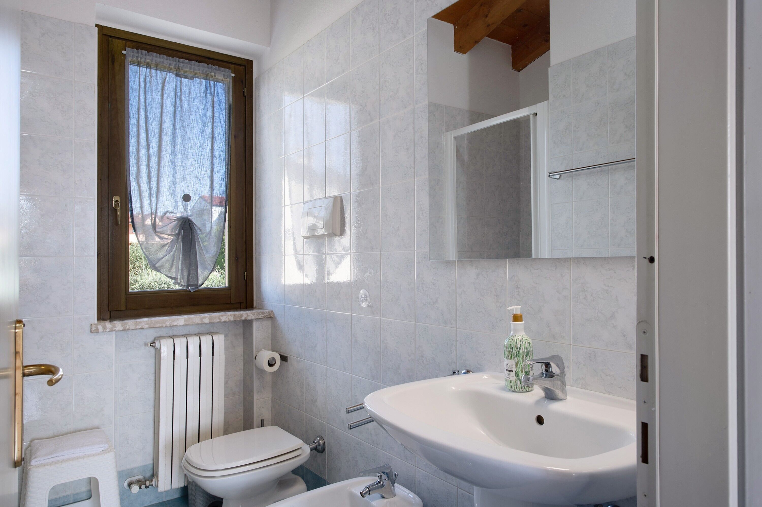 Ein Badezimmer mit Toilette, Waschbecken und Fenster.