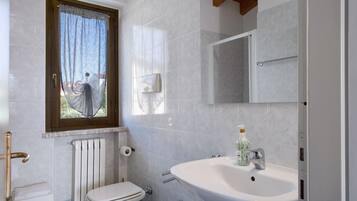 Ein Badezimmer mit Toilette, Waschbecken und Fenster.