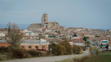Un pueblo con una iglesia destacada que cuenta con una torre alta, rodeado de edificios residenciales.