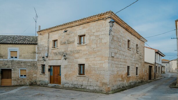 Un edificio in pietra con tetto in tegole, una porta in legno e una piccola finestra.