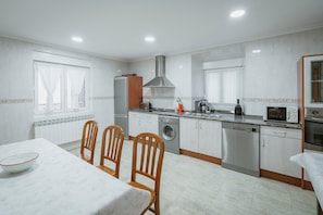 A modern kitchen with a dining area, stainless steel appliances, and a large window. - Country House 'El Humilladero' with Private Terrace (Sasamón)