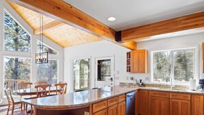 A spacious kitchen with wooden cabinets, a granite countertop, and a large island.