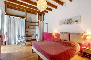 Un dormitorio con cama, escritorio, silla, estante y lámpara de pared.
