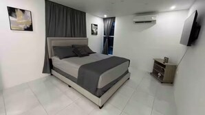 A modern bedroom with a bed, curtains, a TV, and an air conditioning unit.