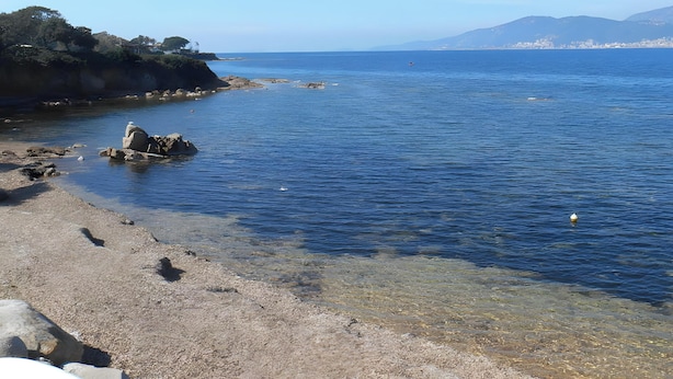 A coastal landscape with clear water, rocky shore, and distant mountains. - Apartment 'Duplex' with Sea View and Balcony (Grosseto-Prugna)