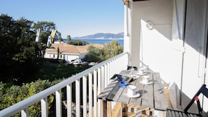 A balcony with a view of the sea, a table with cups and a book, and a white railing. - Apartment 'Duplex' with Sea View and Balcony (Grosseto-Prugna)