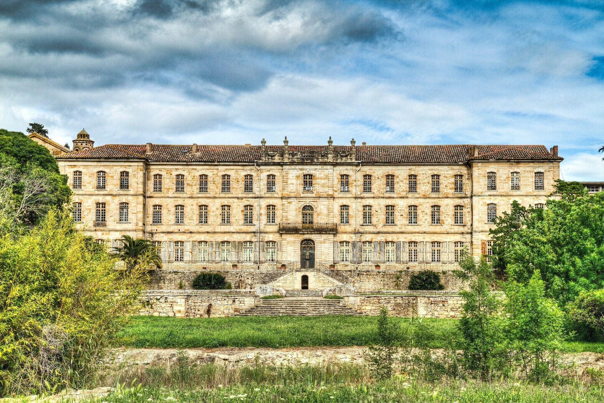 A large, historic building with a symmetrical facade, multiple windows, and a central entrance with steps.