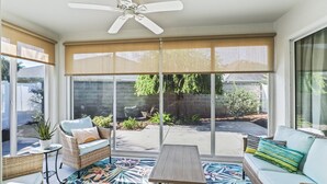 A sunroom with wicker furniture, a ceiling fan, and large windows. - Long term pricing - Charming 2 bed Villa awaits for you. (The Villages)