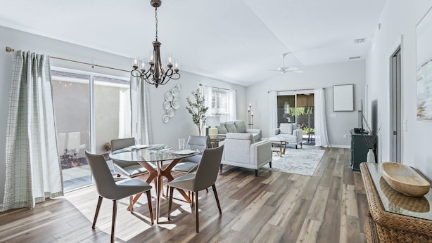 A spacious living area with a dining table, sofas, and a large window. - Long term pricing - Charming 2 bed Villa awaits for you. (The Villages)