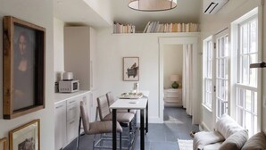 Una cocina moderna con comedor, sofá y estantería.