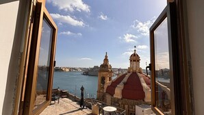 A window with a view of a historic building with a red dome and a bell tower, overlooking a body of water and a cityscape. - Valletta heart two, 3-room superior apartment (Valletta)