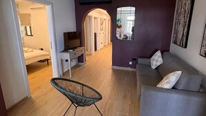 A modern living room with a grey sofa, a black chair, and a wooden floor. - Valletta heart two, 3-room superior apartment (Valletta)