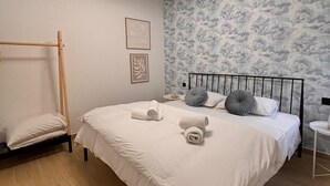 A bedroom with a bed, a wooden ladder, a wall with cloud patterns, and a ceiling light. - Valletta heart two, 3-room superior apartment (Valletta)
