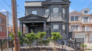 A two-story house with a front porch, a garage, and a fenced yard.