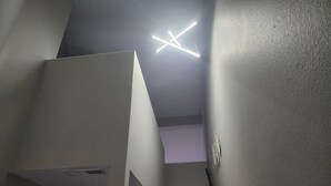 Una escalera con una lámpara moderna en la parte superior.