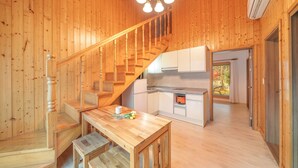 A wooden interior with a staircase, a kitchen, and a dining area. - Gapyeong Sanchaek Glamping Pension (Gapyeong)