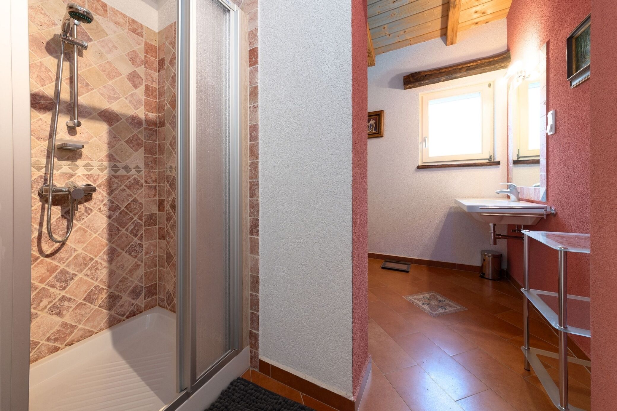 Ein Badezimmer mit Dusche, Waschbecken und Spiegel.