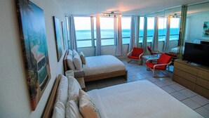 A hotel room with a bed, a TV, a desk, and a view of the ocean. - Castle 1133 Ocean view studio, Pool and Beach Access, FREE Parking, Gym, Tennis and more! (Miami Beach)