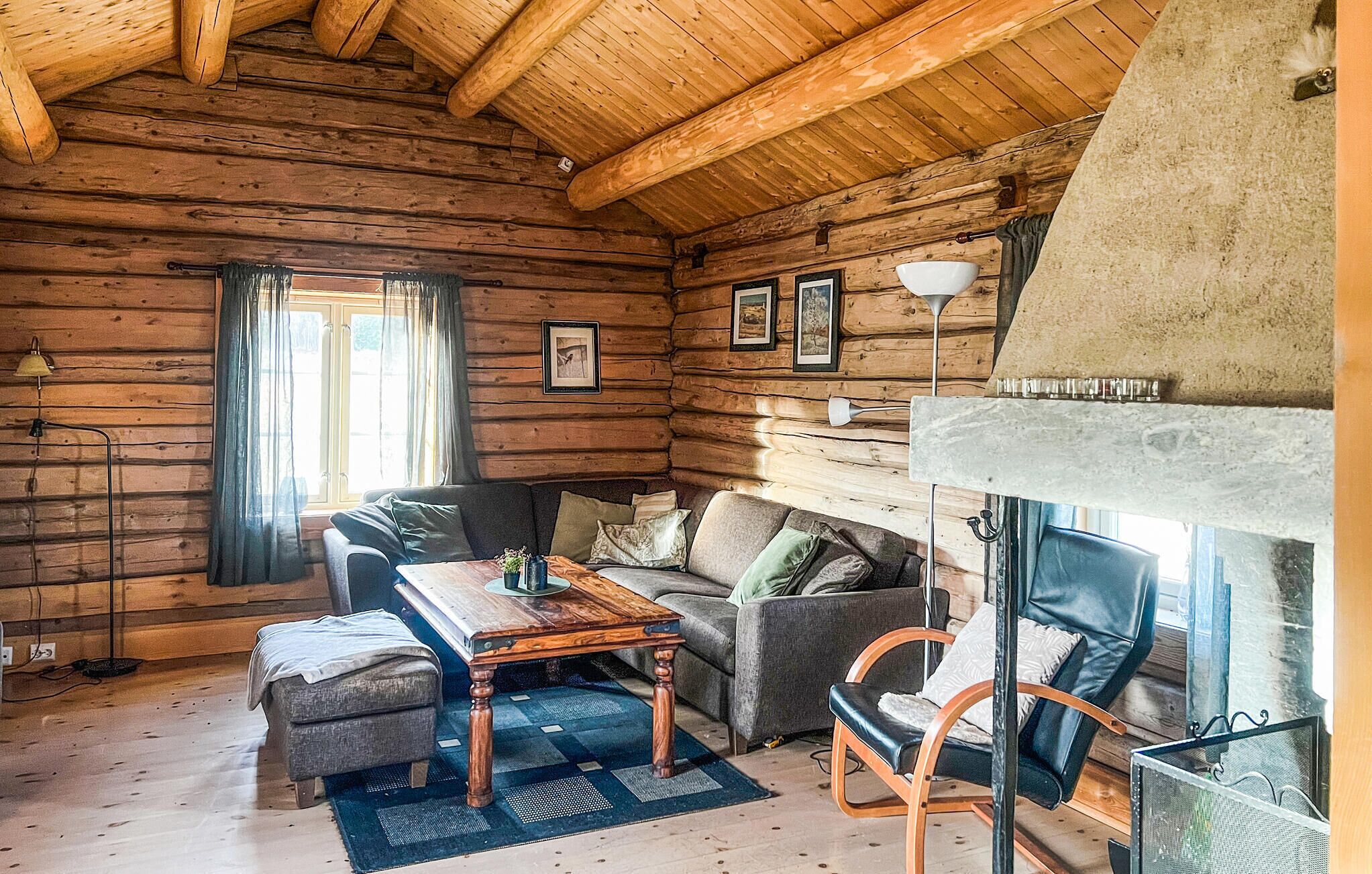 Ein Holzblockhaus-Innenraum mit einer Couch, einem Holztisch und einem Kamin.