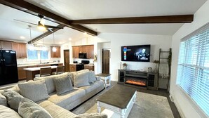 A modern living room with a sectional sofa, a fireplace, and a television mounted on the wall.