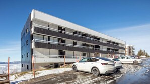 Useita kerroksia sisältävä pysäköintihalli, jonka sisällä on useita parkkeerattuja autoja.