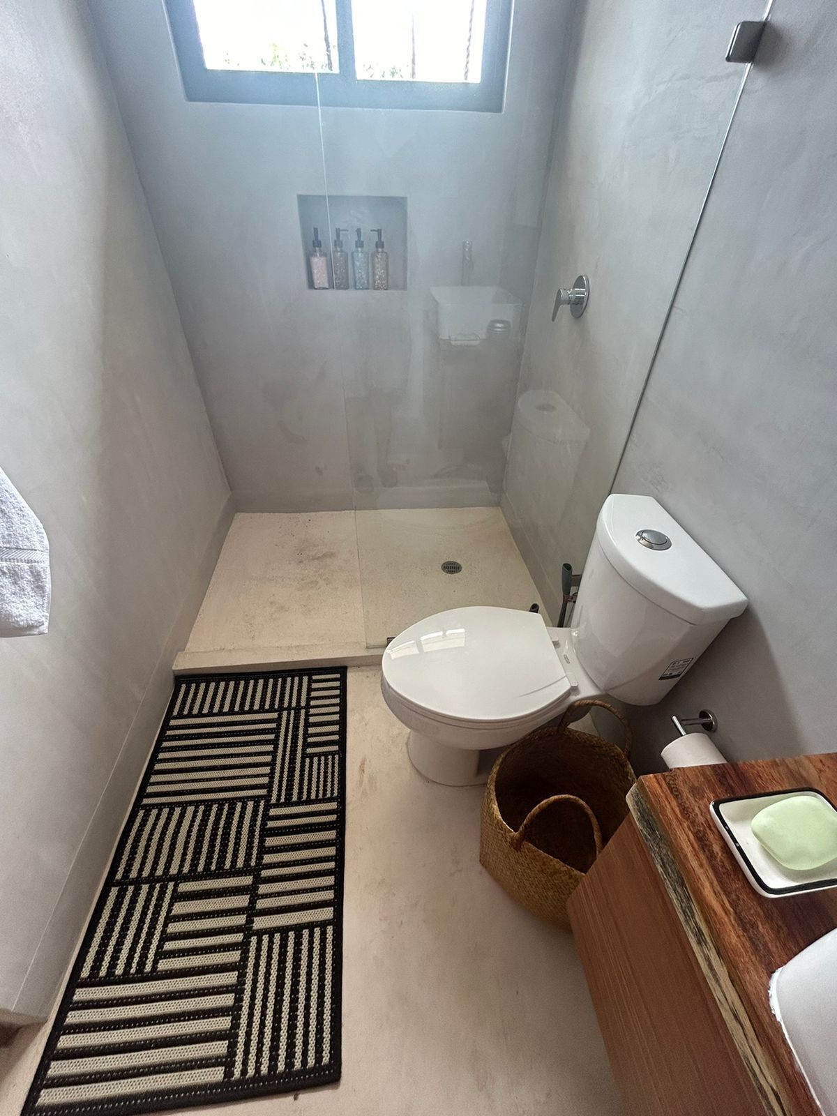 A compact bathroom with a shower, toilet, and a small sink area.
