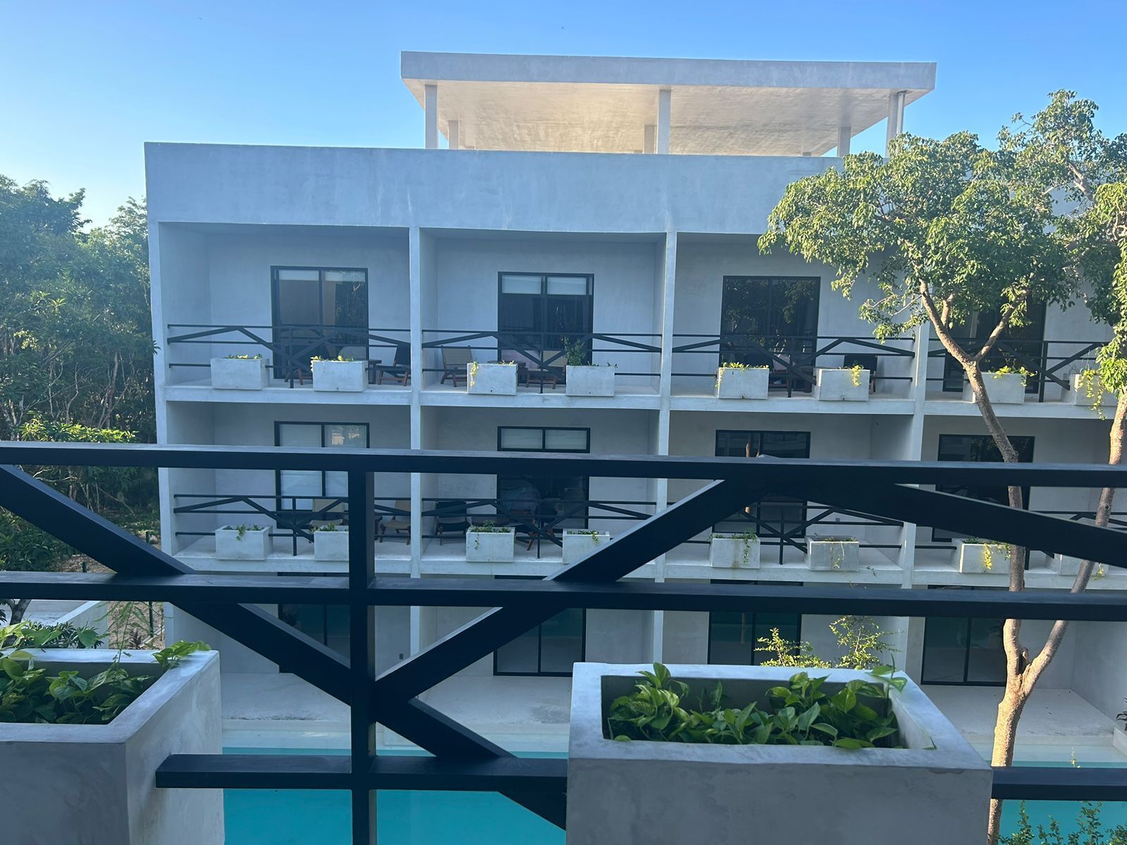A modern building with multiple balconies, each with seating and planters.