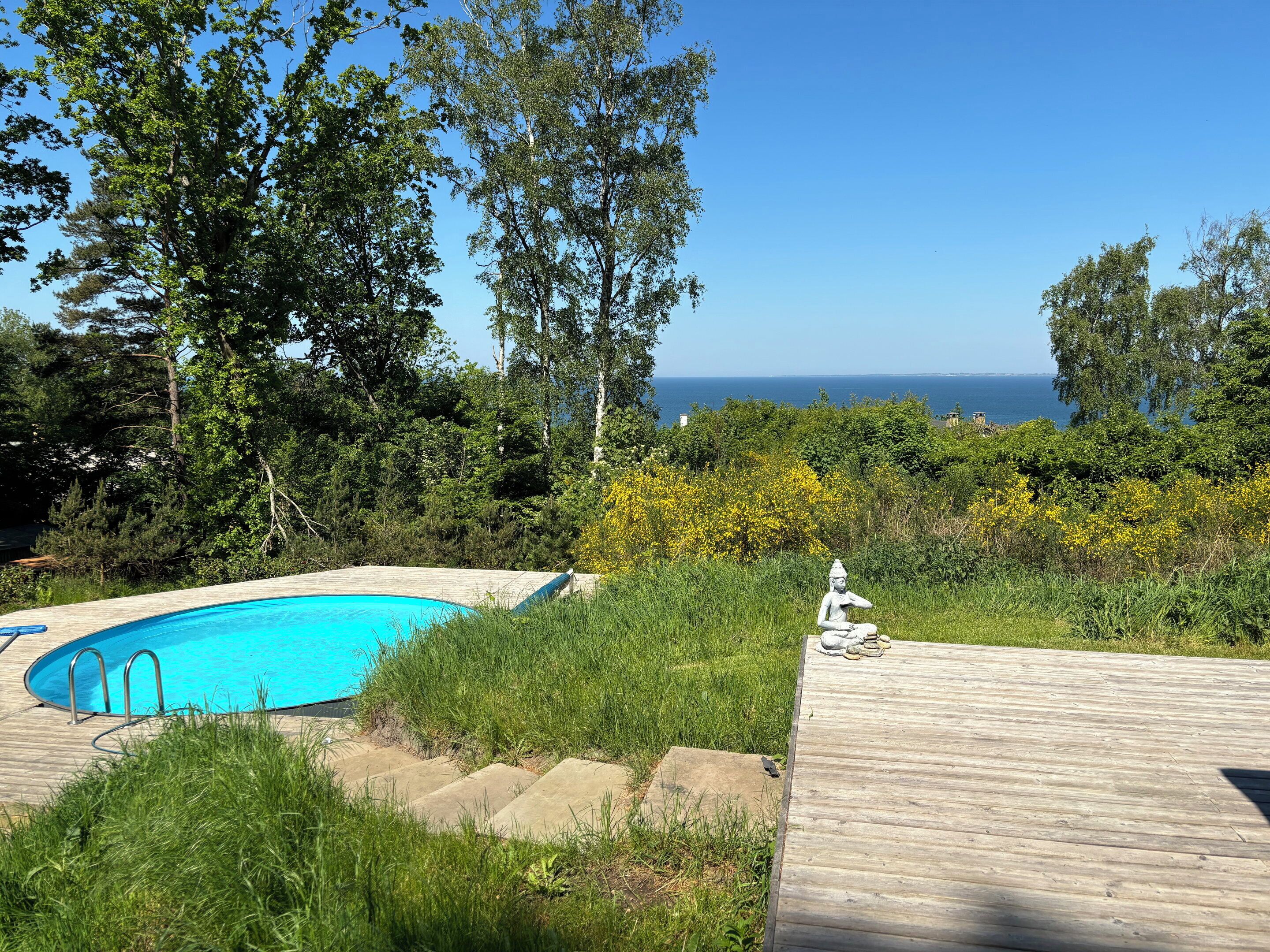 A wooden deck, a swimming pool, and a statue.