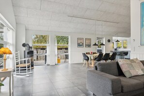 Un vaste espace de vie doté d’une cheminée, d’une table à manger et de meubles modernes.