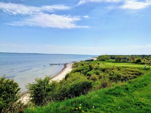 A coastal landscape with a beach, grassy areas, and a clear sky. - 3 bedroom accommodation in Roslev (Roslev)