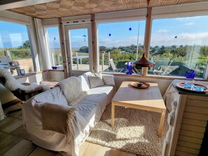 A cozy room with a sofa, a table, and a view of the outdoors. - 3 bedroom accommodation in Roslev (Roslev)