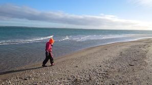 A pebbled beach with a person walking along the shore. - 3 bedroom accommodation in Roslev (Roslev)